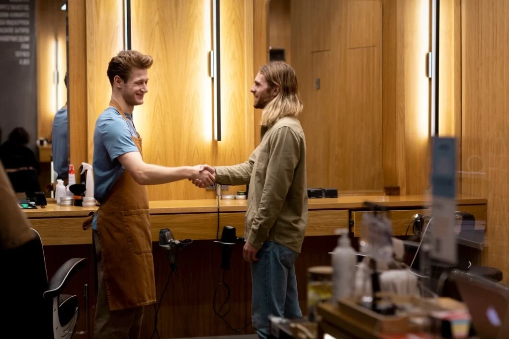 Two professionals shake hands at a local restaurant, showcasing how to market a new restaurant through local partnerships.